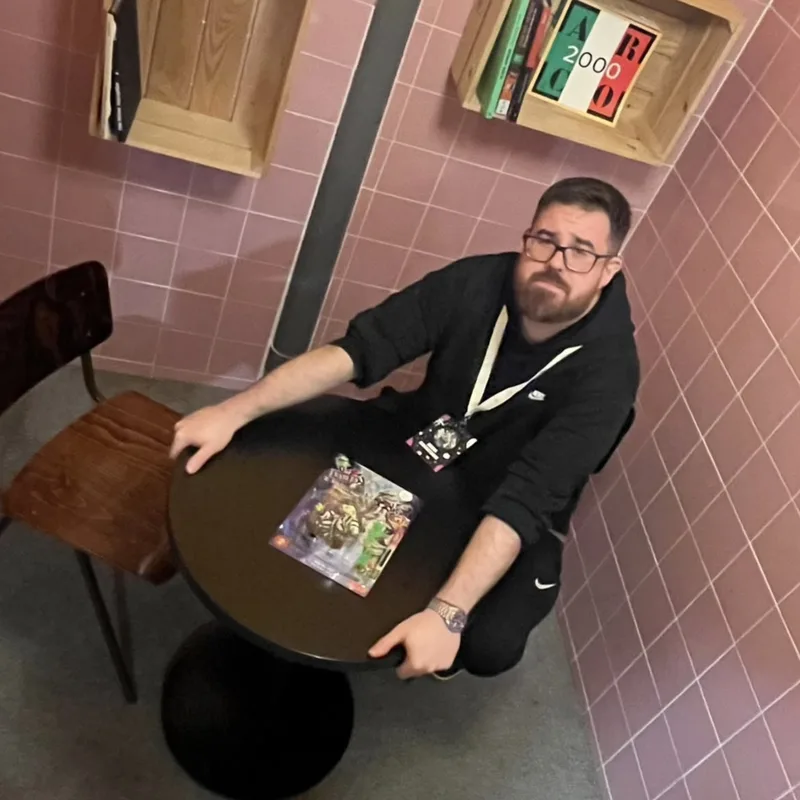 EHIMO sentado junto a una mesa con una figura en blíster